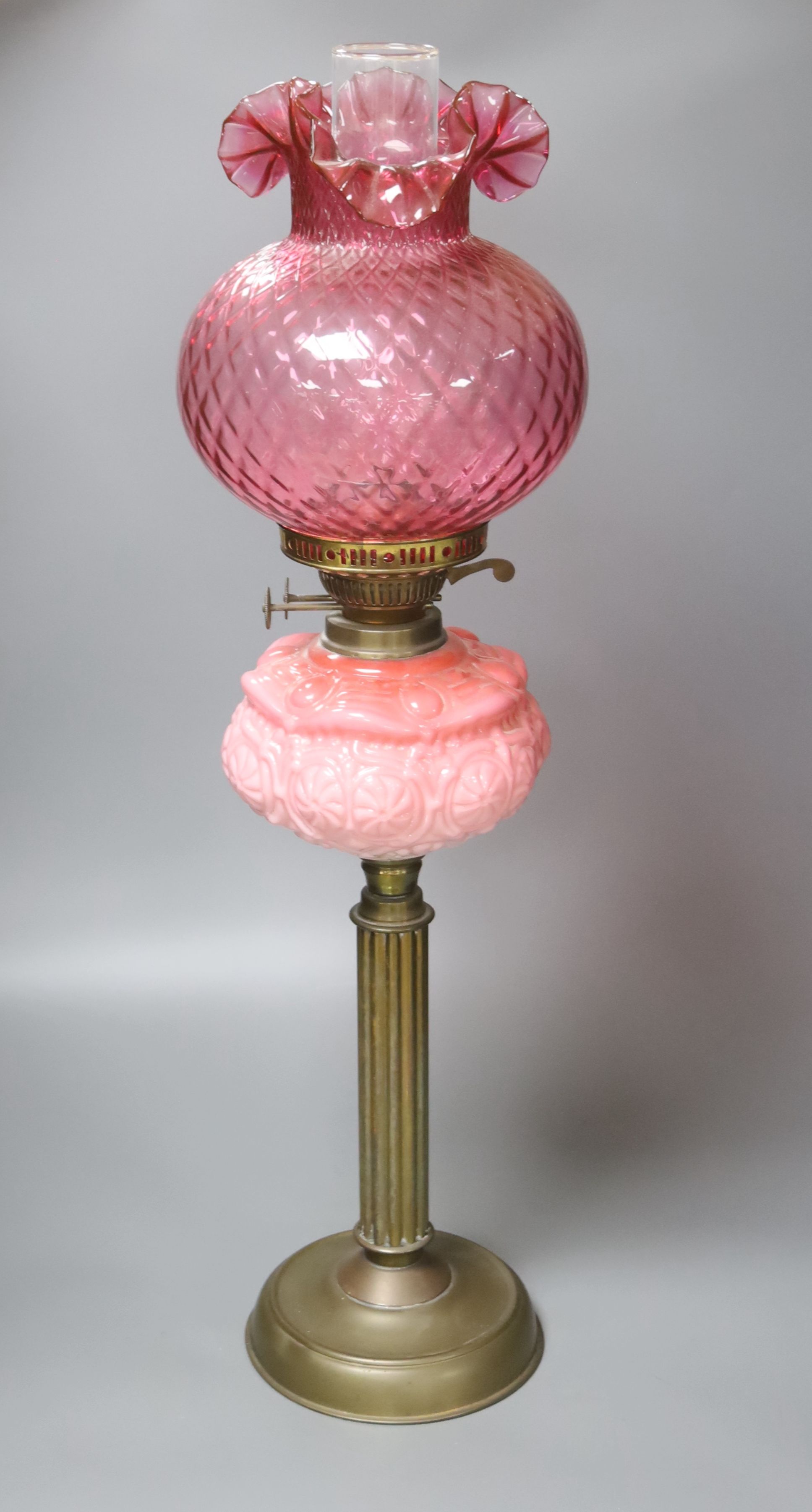 A Victorian brass and pink glass oil lamp, height 70cm